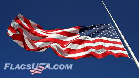 An American flag flying at half-staff with the Flags USA logo