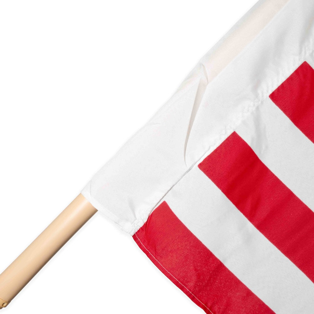 Wooden pole with American flag stripes and pole sleeve heading