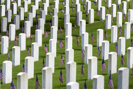 Gravestones and American flag grave markers honoring fallen heroes.