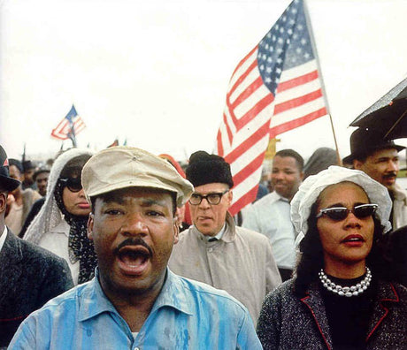 Dr. Martin Luther King Jr. marching with the American flag.