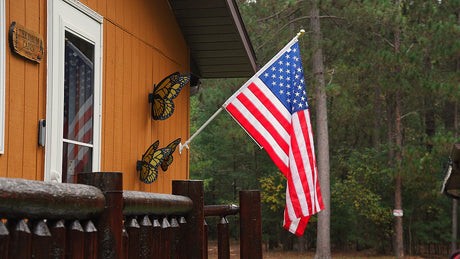 Installed house-mounted spinning flagpole set with American flag 