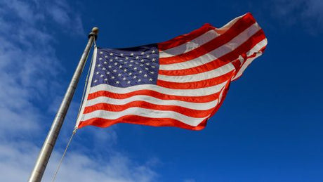 Residential home with a tall American flagpole flying the U.S. flag, symbolizing pride, curb appeal, and increased property value.