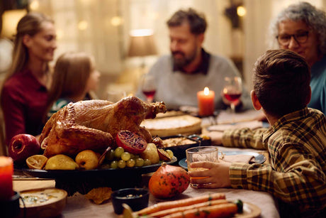 Family gathered around a dinner table, enjoying a Thanksgiving meal.