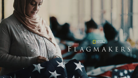 Promotional image for The Flagmakers documentary, showing diverse factory workers sewing and assembling American flags in a production facility.