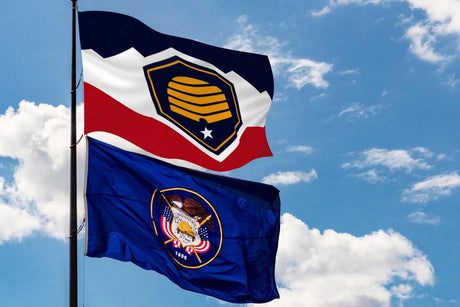 Utah's new flag flying on pole above the historical Utah flag.