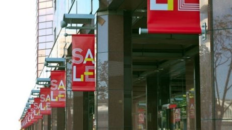A line of red advertising banners outside of buildings