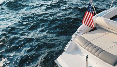American flag flying from a stern-mounted staff on a recreational motorboat.